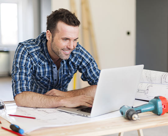 Man on computer paying leasing for Cardinal Leasing Portable Building Trailer